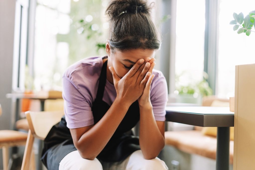 Jeune serveuse fatiguée et malheureuse qui demissionne