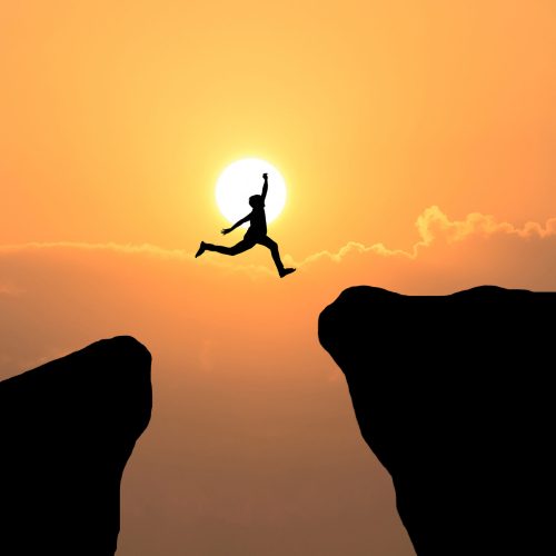 Courage man jump through the gap between hill ,Business concept