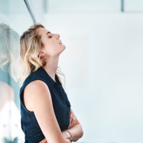 Shot of a young businesswoman looking stressed out in an office